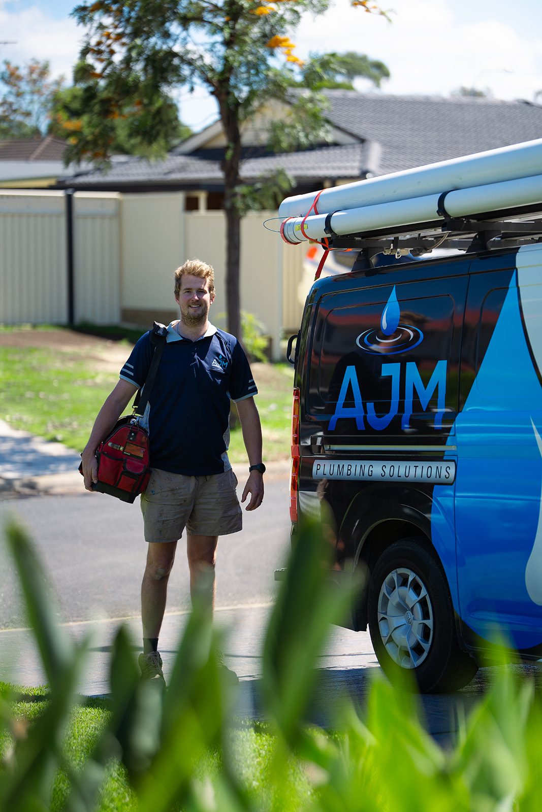 Aaron beside the AJM van on a suburban street