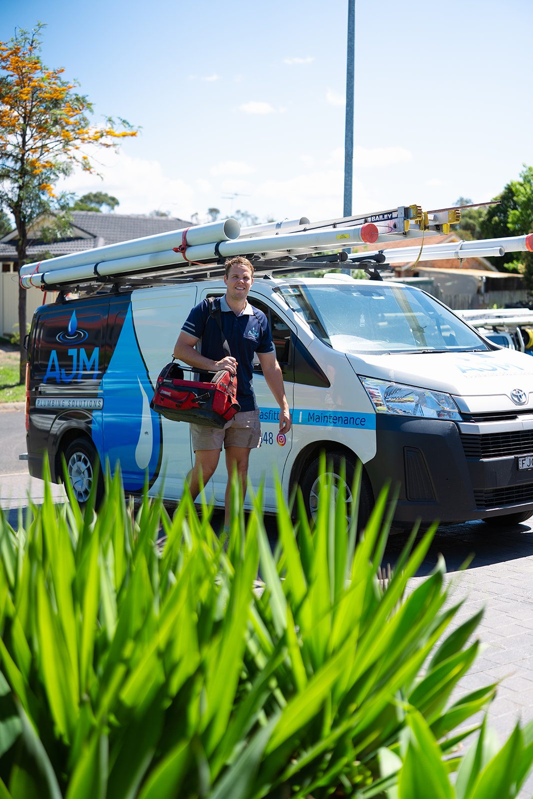 Aaron with his tool bag beside the AJM van