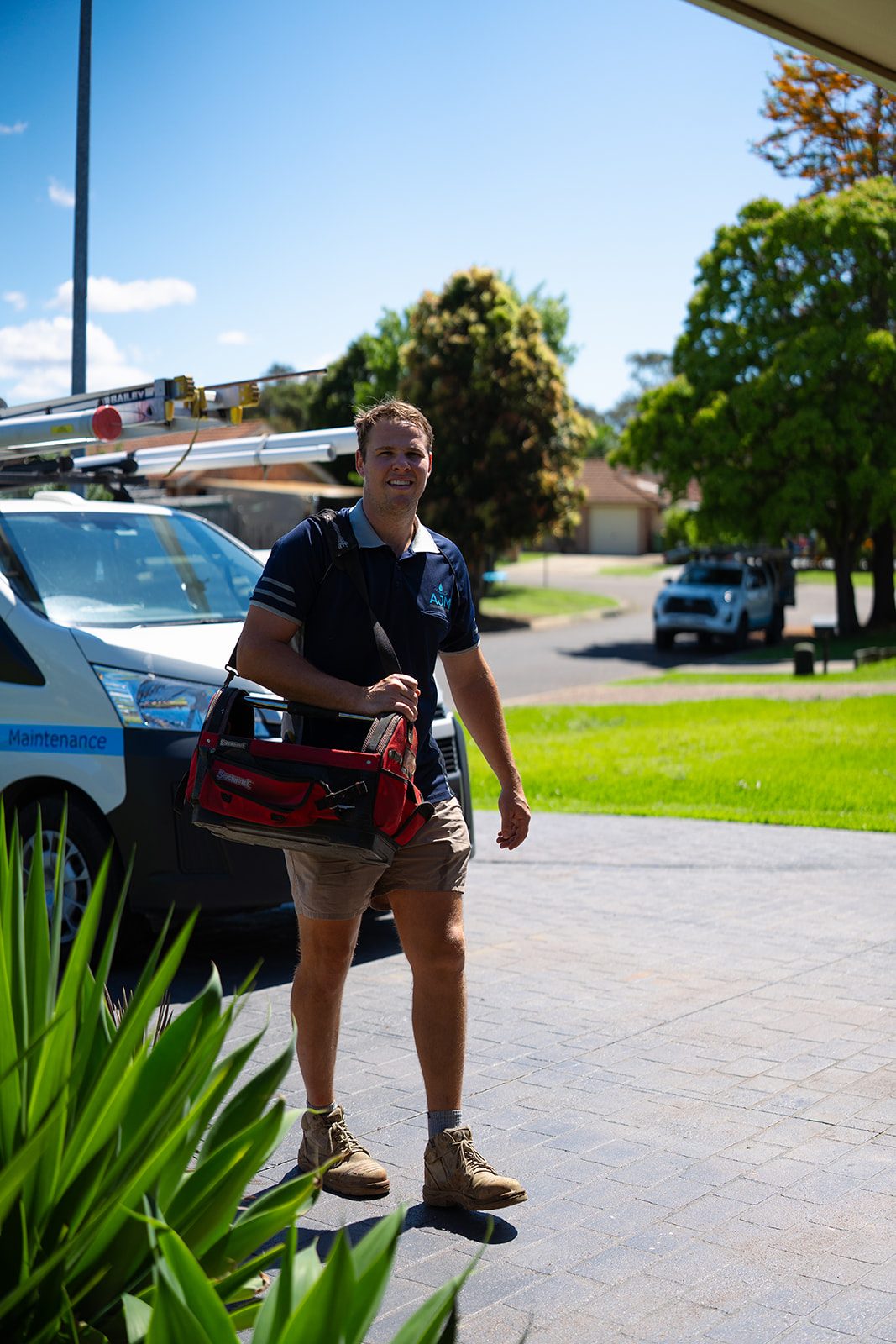 Aaron carrying his tool bag past the van